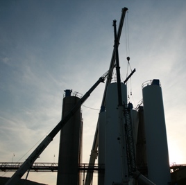 Three cranes rigging silos